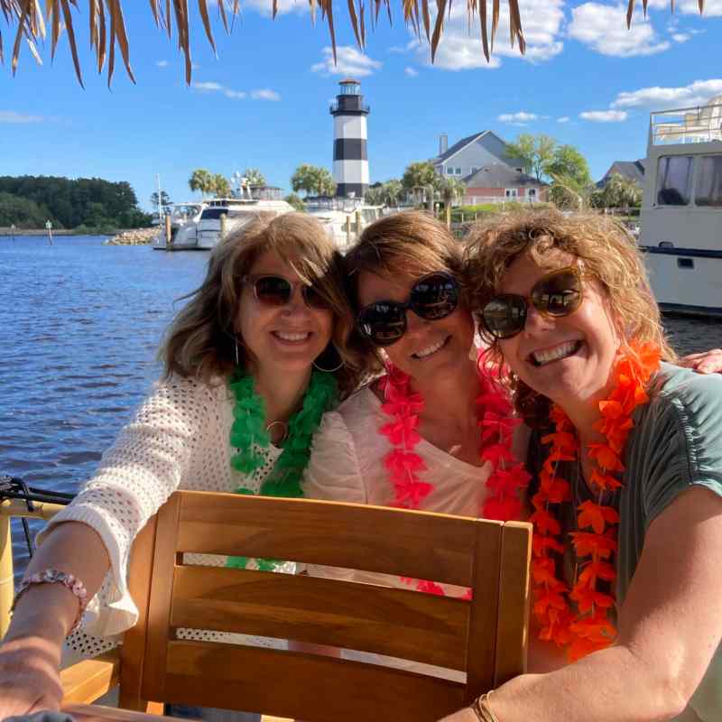 a woman sitting on a bench in front of a lake