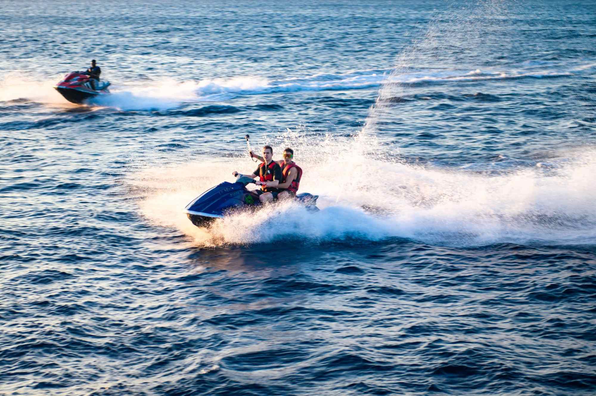 The History of Jet Skiing a group of people riding skis on a body of water