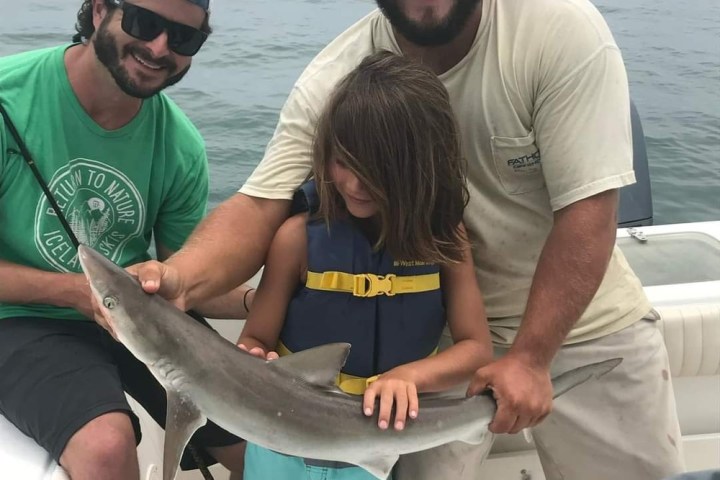 a person holding a fish in the water