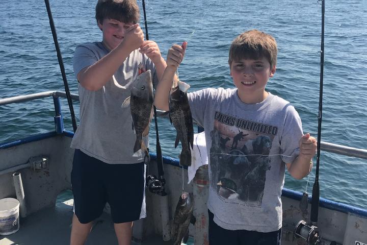 a man holding a fish on a boat posing for the camera