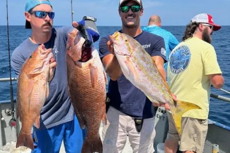 a group of people standing next to a man holding a fish