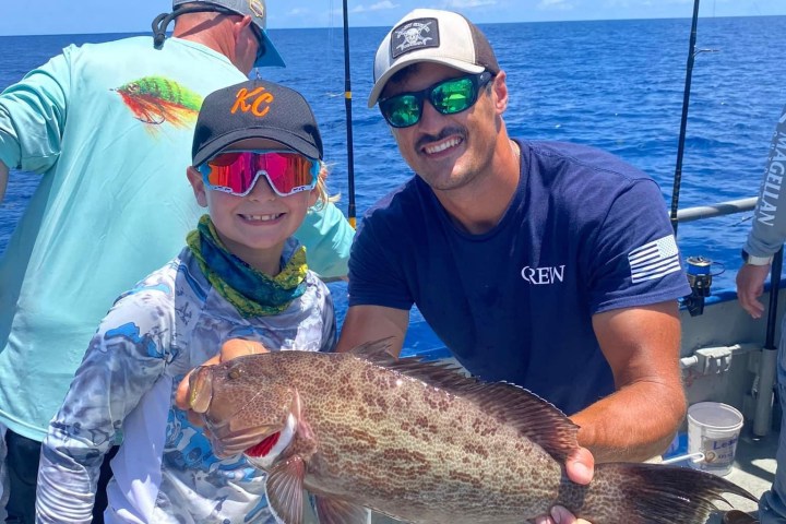 a person holding a fish in the water