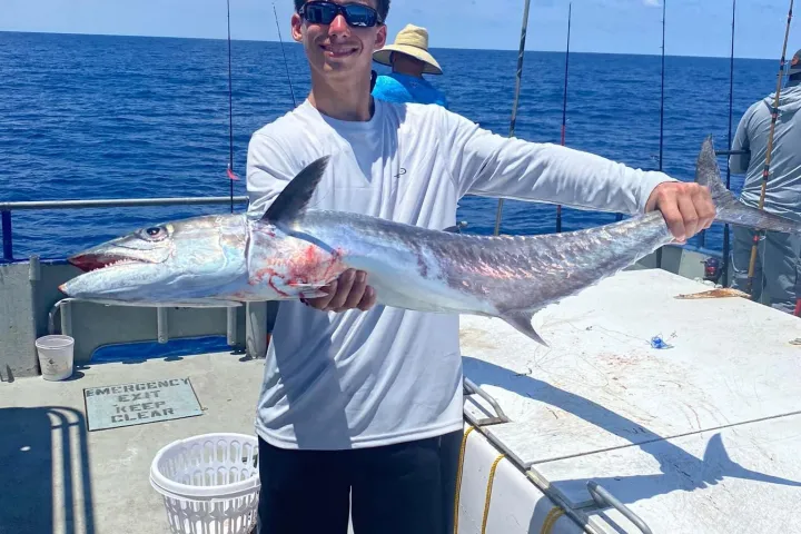 a man holding a fish in the water