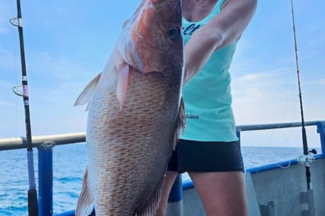 a woman holding a fish in the water