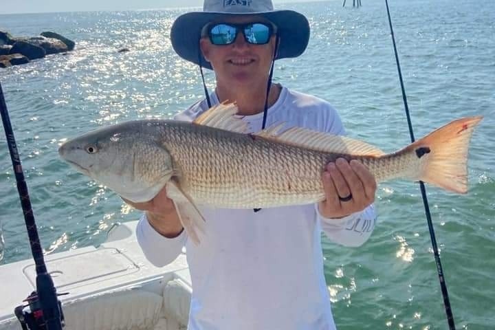 a man holding a fish on a boat in the water