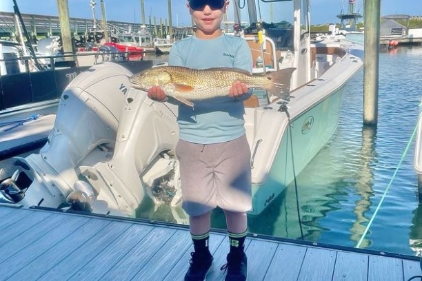 a child with a red drum fish