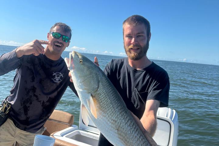a man holding a fish in the water