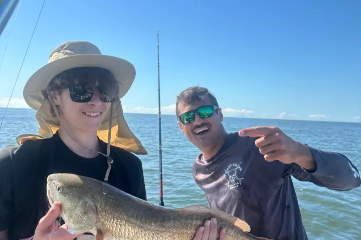 a person holding a fish on a boat