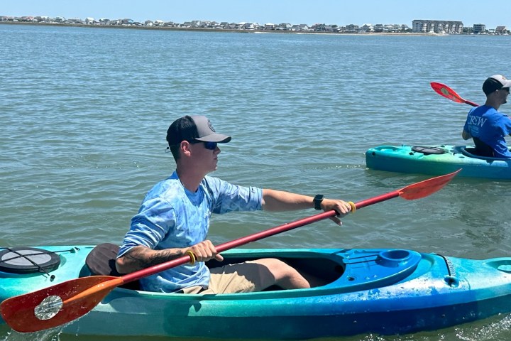 a person riding on the back of a boat in a body of water