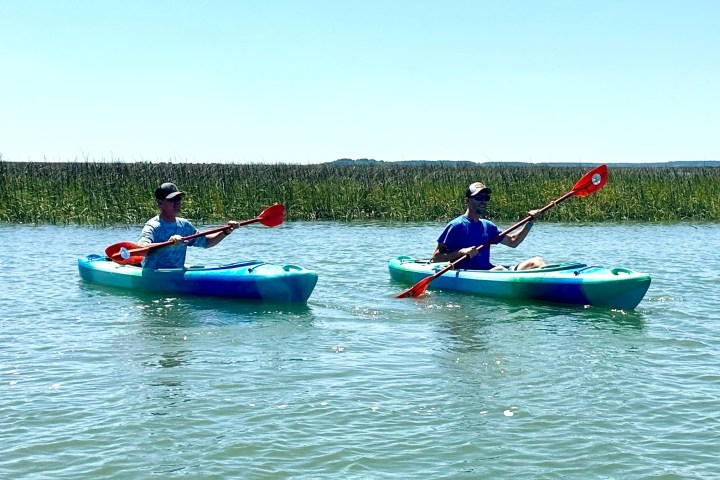 a group of people riding on the back of a boat in the water