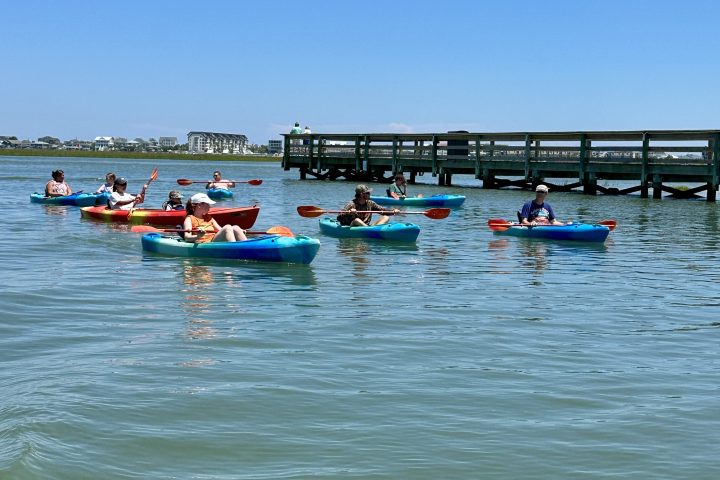a group of people rowing a boat in the water