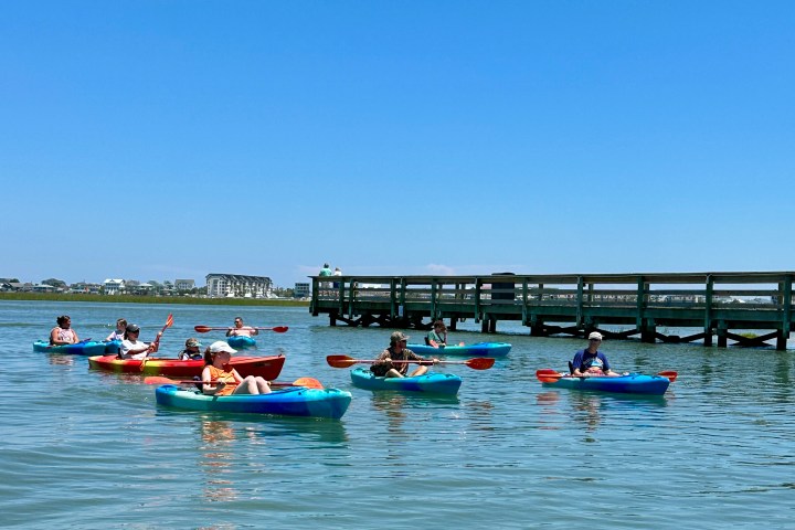 a group of people rowing a boat in the water