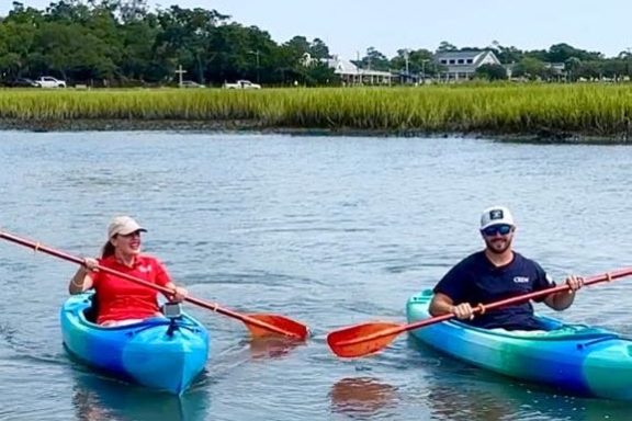 a group of people rowing a boat in a body of water