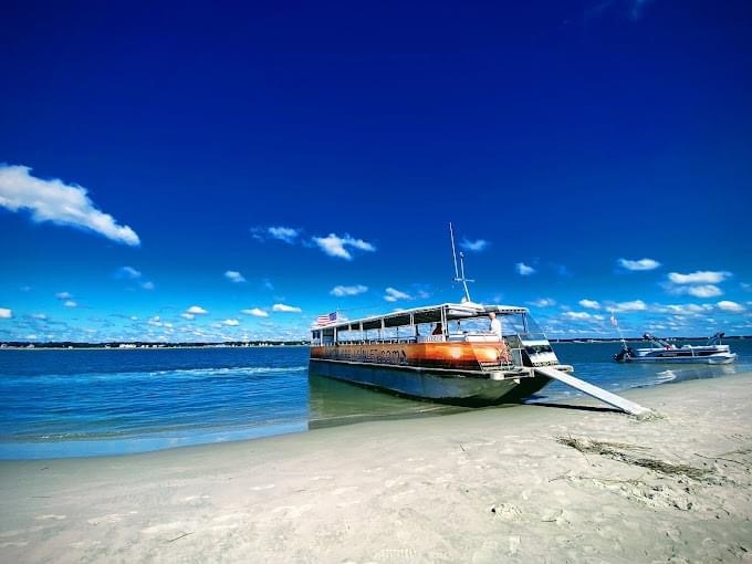 a blue and white boat sitting next to a body of water