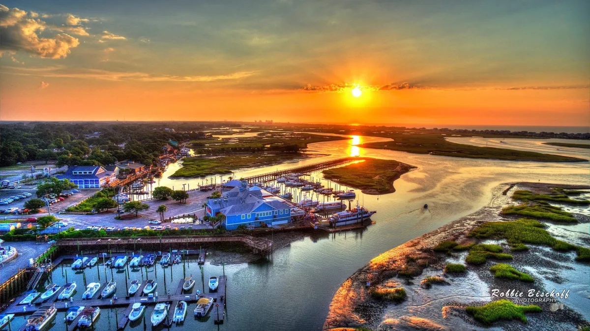 The Marshwalk of Murrells Inlet a sunset over a body of water