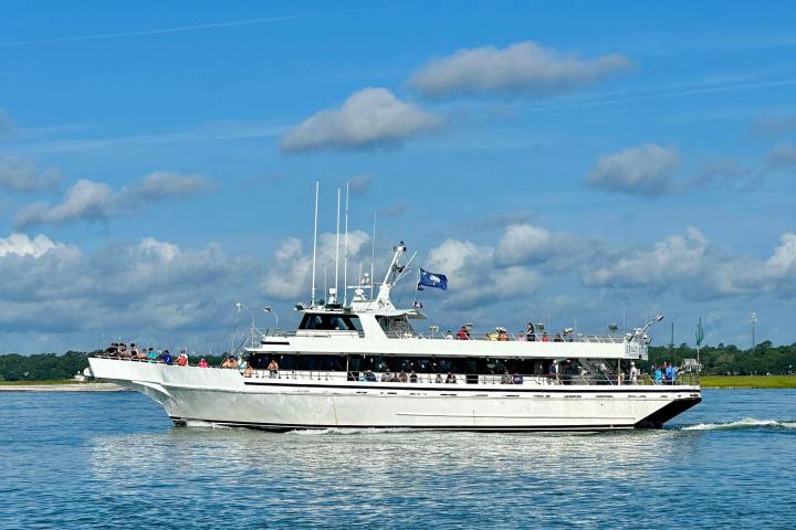 White passenger ferry on water with blue sky and scattered clouds.