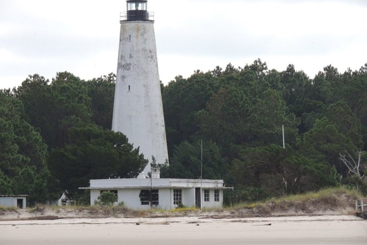 a large tower with a clock on the side of a road