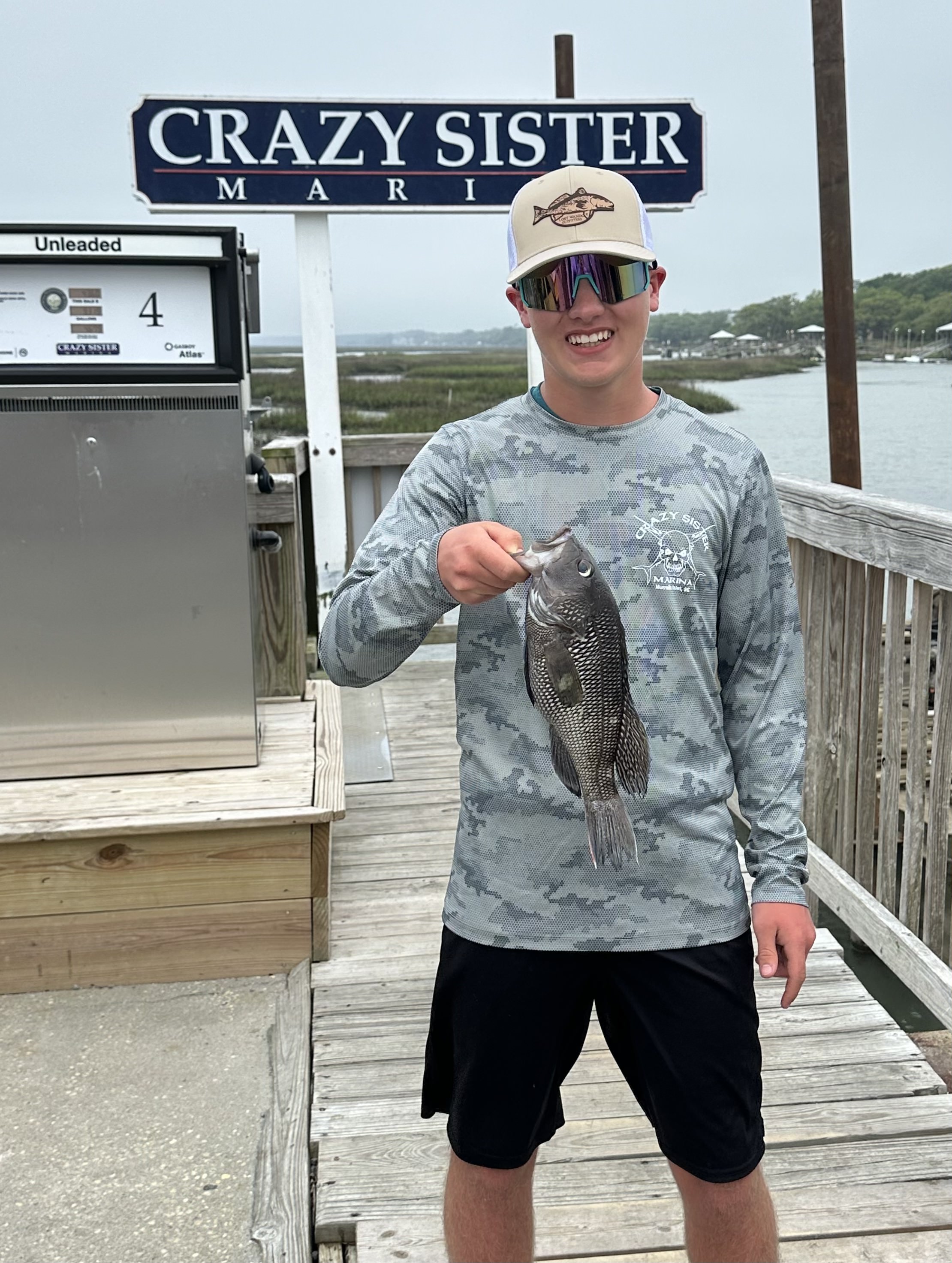 IMG_7291 A man proudly holding up a freshly caught black sea bass onboard our Crazy Sister Marina fishing charter.
