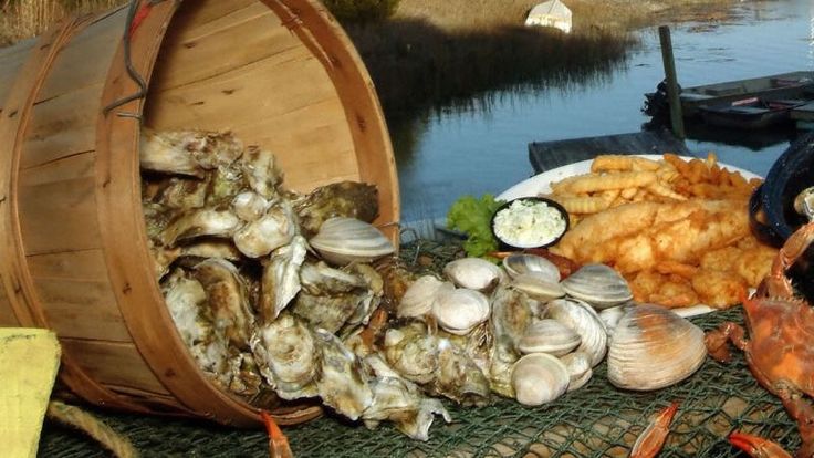 oysters in murrells inlet Basket of oysters and clams beside fried fish on a dock by the water.