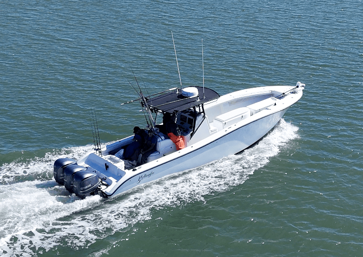 White speedboat with three engines cruising on blue water.