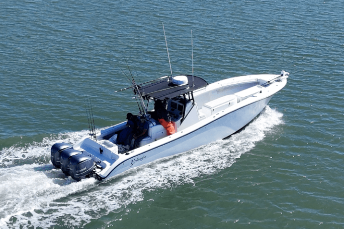 White speedboat with three engines cruising on blue water.