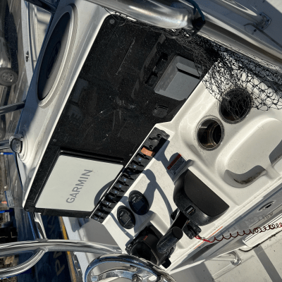 Boat steering console with Garmin screen and cup holders.