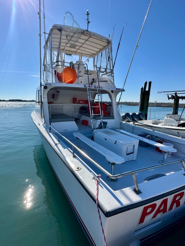 Fishing boat docked on calm waters on a sunny day.