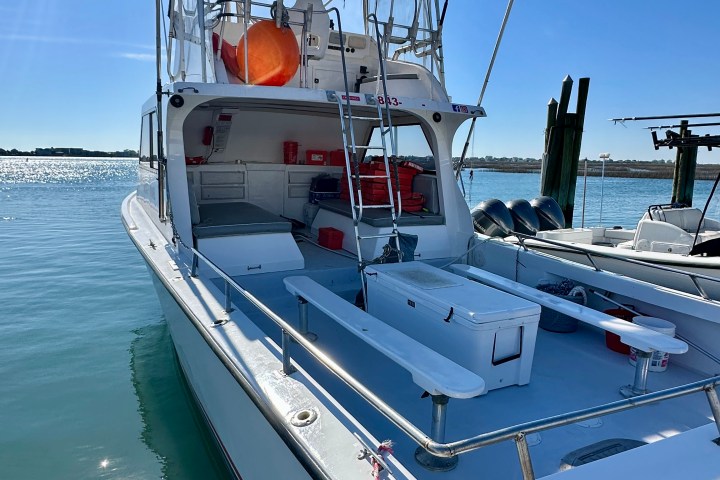 Fishing boat docked with equipment and a clear blue sky in the background.