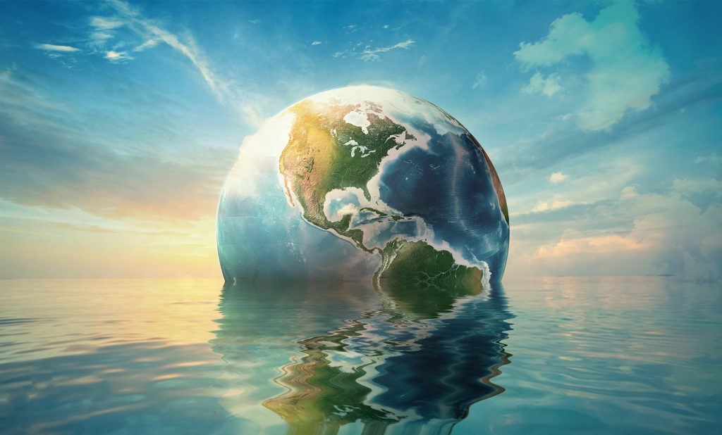 Earth partially submerged in an ocean with a sunset background.