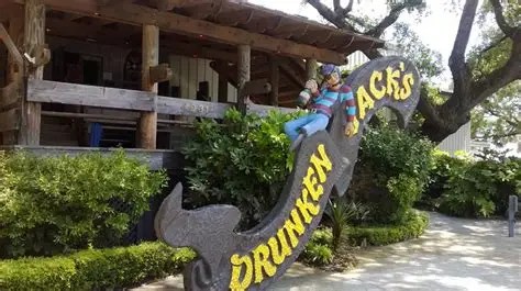 Sign reading 'Drunken Jack's' with pirate figure, outside a wooden building.