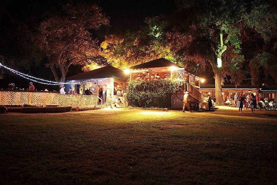 Cozy outdoor event at night with string lights and illuminated tents.
