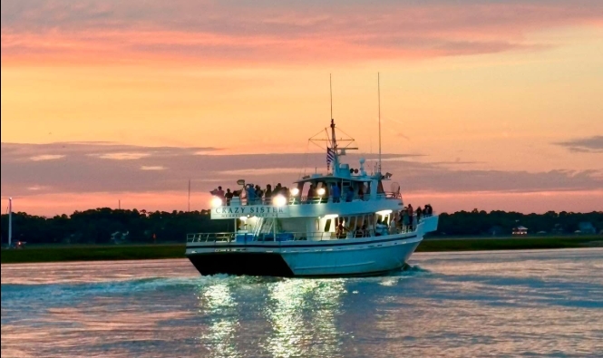 A boat on calm water at sunset with a colorful sky.